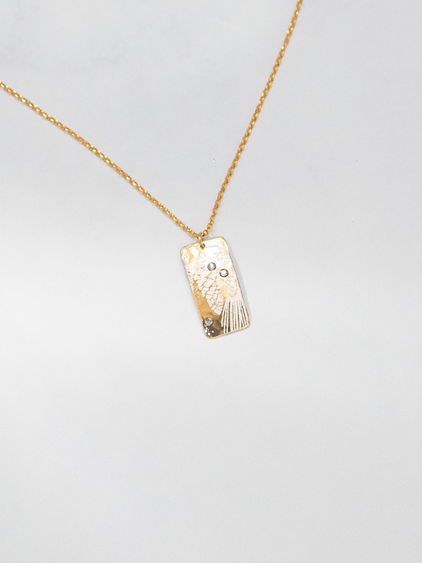 The Radiant Petra Pendant Necklace wows with pinecone art and